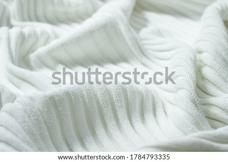 Background from natural fabric. Very soft knitted cotton of white color with stripes and folds. The surface of cotton corrugated blanket for baby borns or warming in cold weather.  Royalty-Free Stock Photo #1784793335