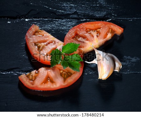 Healthy tomato slices with parsley and garlic cloves. Healthy and organic foods. Clean eating diet