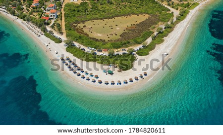 Aerial drone top view photo of amazing exotic sandy peninsula with turquoise clear sea and sun beds in Mediterranean destination