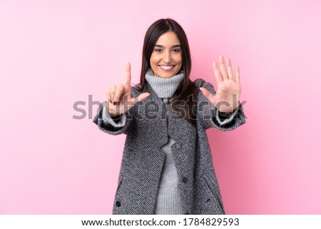 Young brunette woman over isolated pink background counting seven with fingers