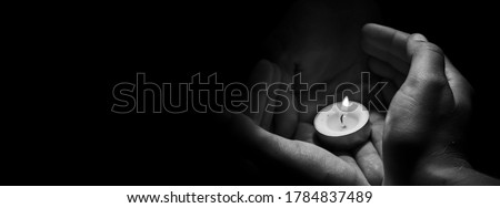 Candle in hand burning on the black background. Royalty-Free Stock Photo #1784837489