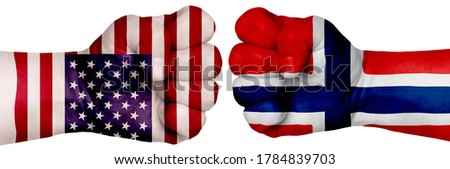 The concept of the struggle of peoples. Two hands are clenched into fists and are located opposite each other. Hands painted in the colors of the flags of the countries. Norway vs USA