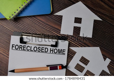 Foreclosed Home text write on paperwork isolated on office desk.