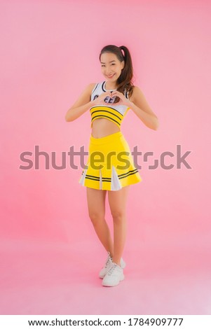 Portrait beautiful young asian woman cheerleader on pink isolated background