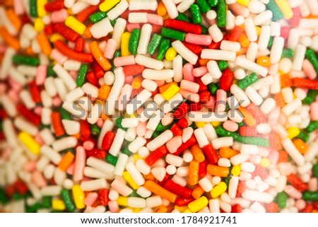 Close up of colorful sweet sprinkles topping for ice cream in a glass jar on the counter