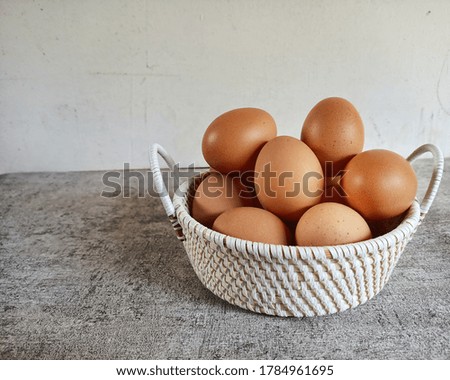 eggs in a white basket, gray background.