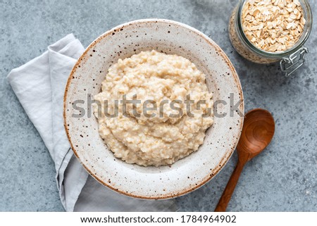 Plain oatmeal porridge in bowl. Healthy vegan vegetarian breakfast food, whole grain porridge oats Royalty-Free Stock Photo #1784964902