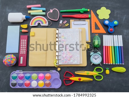 Stationery chalk board. Back to school. Open notepad on top of office supplies. Children kawaii stationery for school. Flat lay