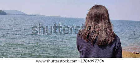 Picture of a girl beside a lake  image hiding photo