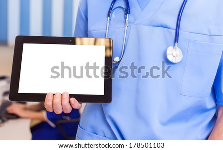 Male doctor using a tablet computer in a hospital.