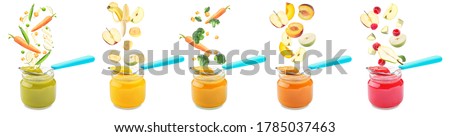 Many jars with healthy baby food and falling ingredients on white background Royalty-Free Stock Photo #1785037463