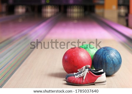 Balls and shoes on lane in bowling club
