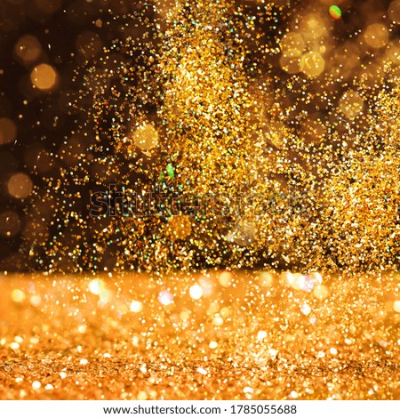 Luxury golden glitters on dark background. Bokeh effect 
