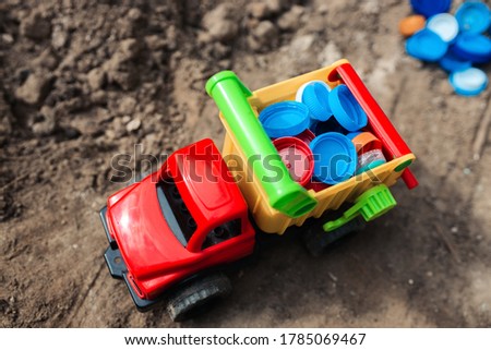 Plastic recycling concept. Toy truck transporting plastic caps.