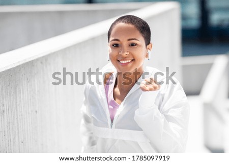 fitness, sport and healthy lifestyle concept - happy smiling young african american woman running upstairs outdoors