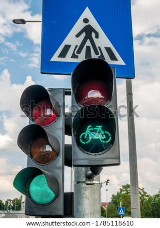 Traffic light against blue cloudy sky. Traffic lights for bicycles.