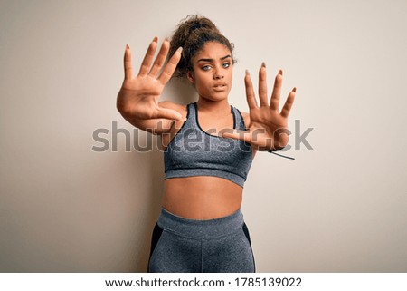 Young african american sportswoman doing sport wearing sportswear over white background doing frame using hands palms and fingers, camera perspective
