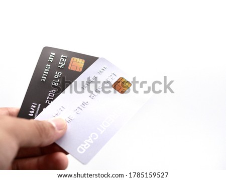 Picture of an isolate of a hand holding 2 credit cards  Is a gray card and a black sticking out in front
