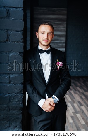 Portraits of the groom at the hotel training camp, dressed as a businessman in a black suit, tuxedo and white shirt