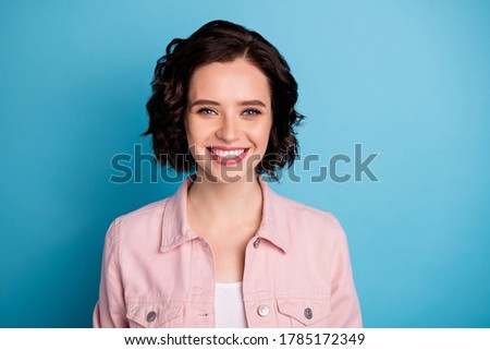 Closeup photo of attractive pretty lady groomed short black hairdo toothy beaming smiling good mood wear casual pink denim jacket isolated blue color background
