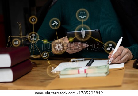Law and Legal services concept, Good service cooperation, lawyer woman working on wood table office, law virtual screen interface icons, Background toned image blurred.