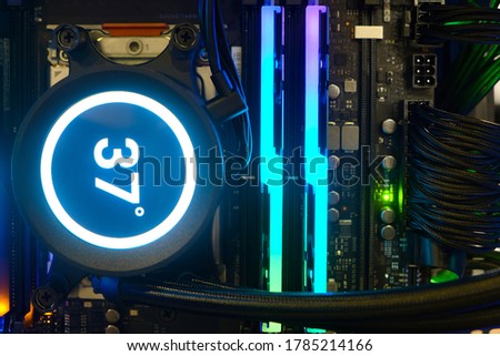 Close-up Cooling Pump on CPU socket of motherboard with number temperature display and multicolored LED RGB light show status  on working, inside Computer PC Case and DIY, technology background