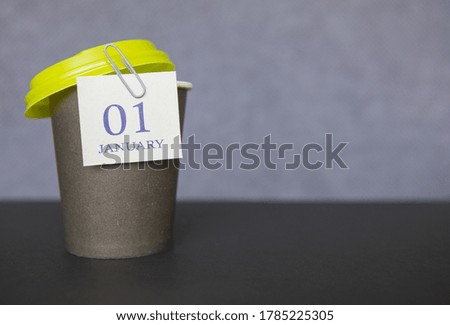 Coffee paper cup with calendar dates for January 01, Winter season. Time for relaxing breaks and vacations.