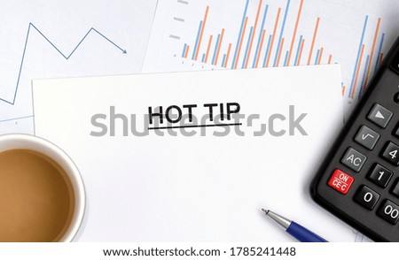 Hot tip document with graphs, diagrams and calculator and a cup of fragrant coffee