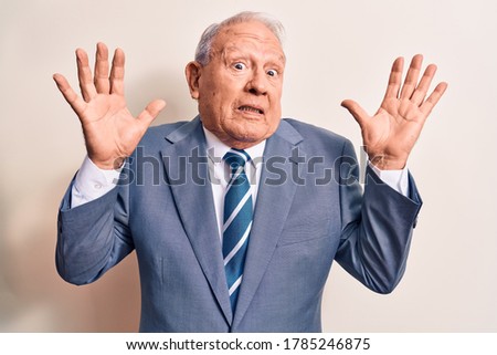 Senior handsome grey-haired businessman wearing elegant suit over white background clueless and confused with open arms, no idea and doubtful face.