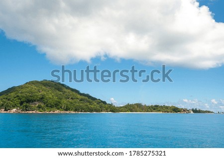 A rocky island with sea and blue sky in the background