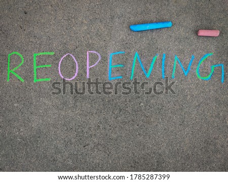 The inscription on the grey board "REOPENING". Using color chalk pieces. Reopening of shops,schools,malls,theatres,showrooms etc.. 