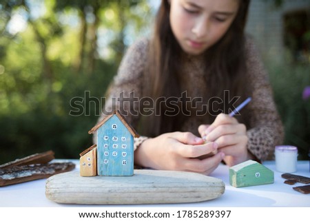 creative craft with kids. children's wooden houses made of natural materials. process of creating handcraft. child do art in nature. Royalty-Free Stock Photo #1785289397
