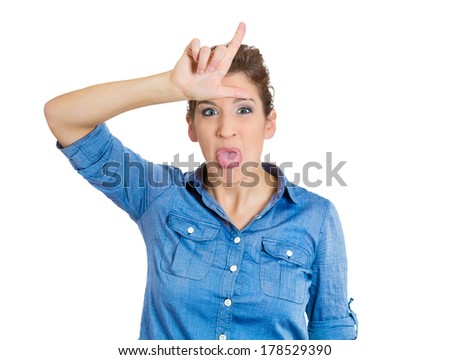 Closeup portrait of angry, mad, upset, pissed young woman, displaying loser sign with hand on forehead, isolated white background. Negative human emotions, facial expressions signs, symbols, feelings 