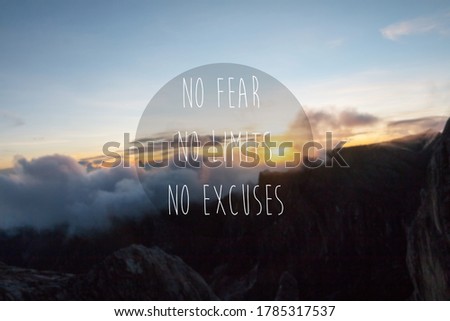Blurry sunrise on mountain top with quote - No Fear, No Limits, No Excuses