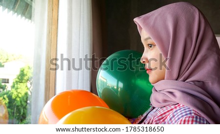 Asian girl is playing with balloons in the bedroom