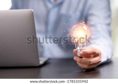 Businessman hand holding lightbulb with orange glowing for creative thinking idea concept. Royalty-Free Stock Photo #1785335942