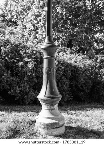 Monochrome photograph of a lamp post shot in a park in Sweden.
The morning sun illuminates the side of the lamp post. It is shot with a medium format camera.