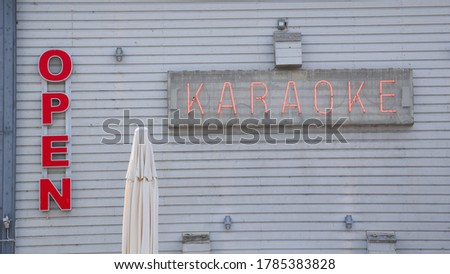Open Sign And Karaoke Sign On Wooden Wall In The Daytime