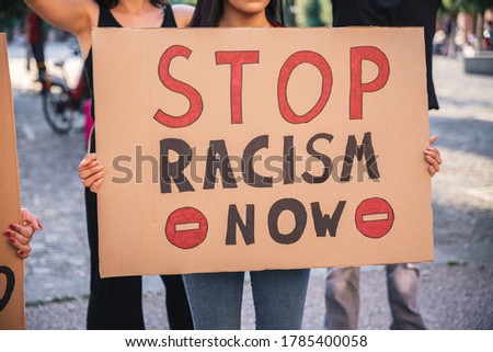 Group of young demonstrators in a road - People protesting for equality and for stop the racism - Detail of the signs with  inscriptions and symbols