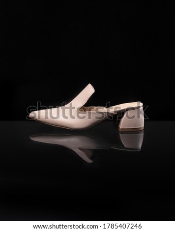 
actual women's shoes on black glossy background