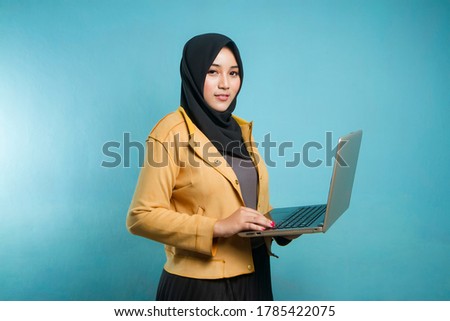 young Indonesian woman holding laptop on isolated background