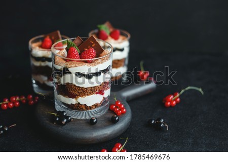 Sweet small homemade trifle dessert with raspberries, black currants, and cream cheese. Royalty-Free Stock Photo #1785469676