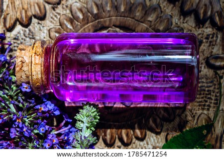 close-up of a horizontal glass stopper bottle with pink purple liquid