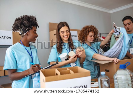 Helpful team of social workers. Group of mixed race people working in charitable foundation. Somebody's little is someone's everything. Young people sorting donations Royalty-Free Stock Photo #1785474152