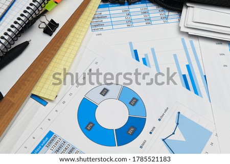 business office desk closeup - financial reports, analysis and accounting, set of documents, tables and graphs, various items for bookkeeping, calculator
