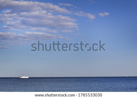 Blue sea water horizon with sky white boat and clouds summer outdoor fun concept