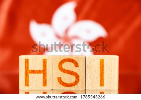 hsi index hong kong. wooden blocks with hsi lettering on hong kong flag background