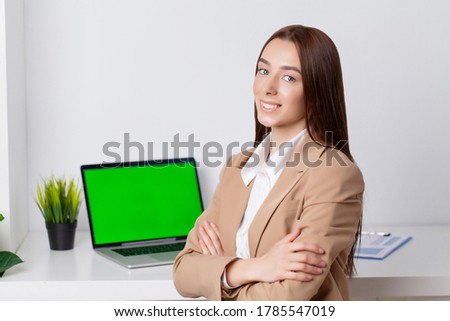 Beautiful young woman in a jacket working in the office at the desk
