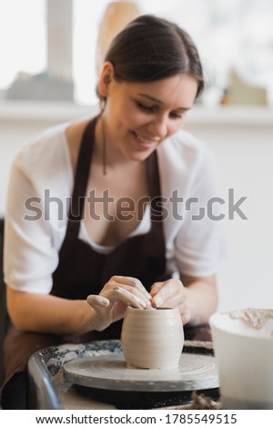 Close-up of potter making pot in pottery workshop. Using sponge and water for moisturizing clay.