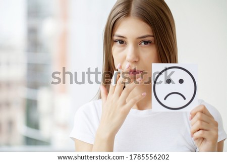 Stop smoking, woman holding a broken cigarette and a card with a smile